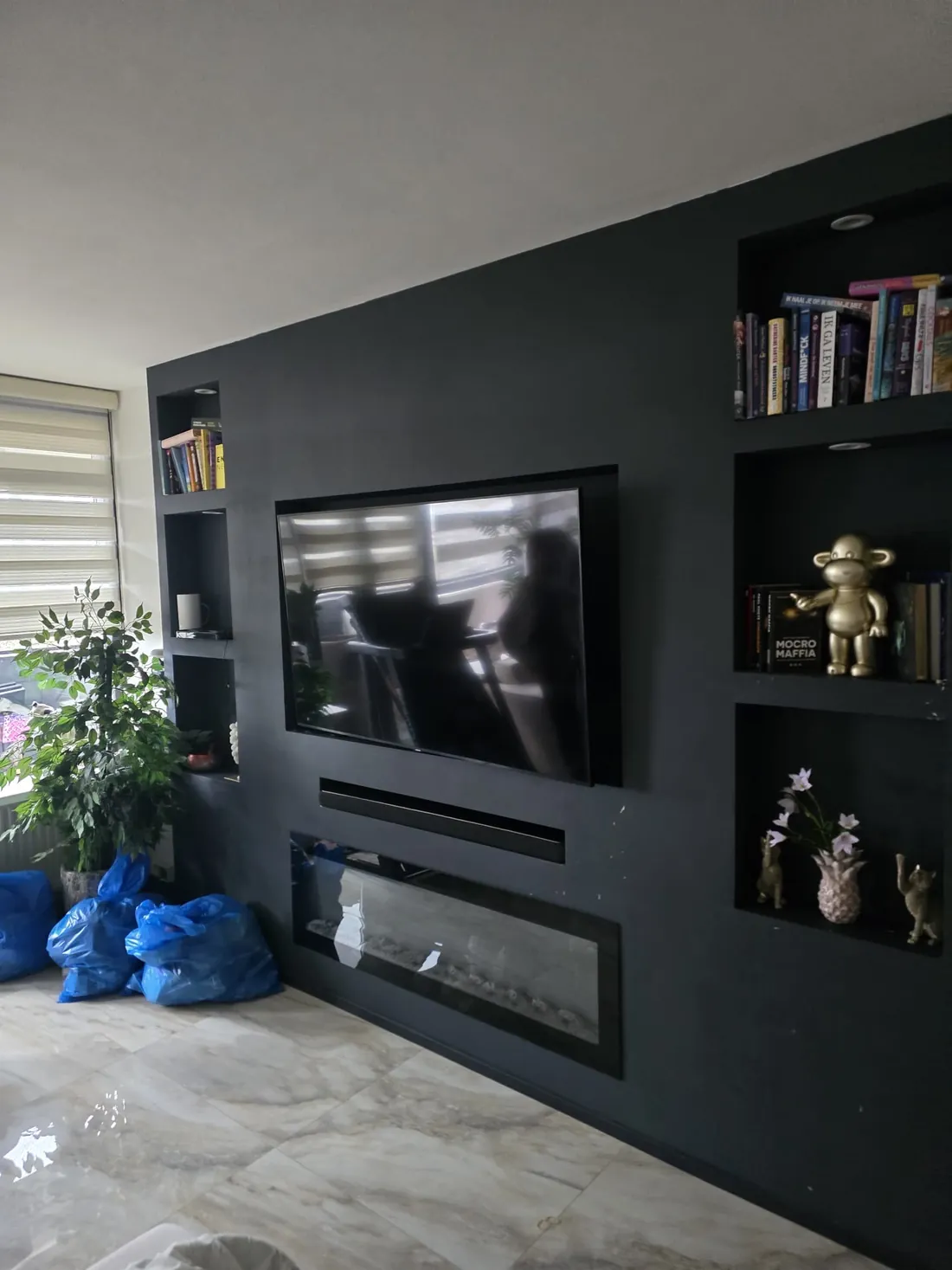 Donkergroene wand met ingebouwde nissen en afgedekte vloer