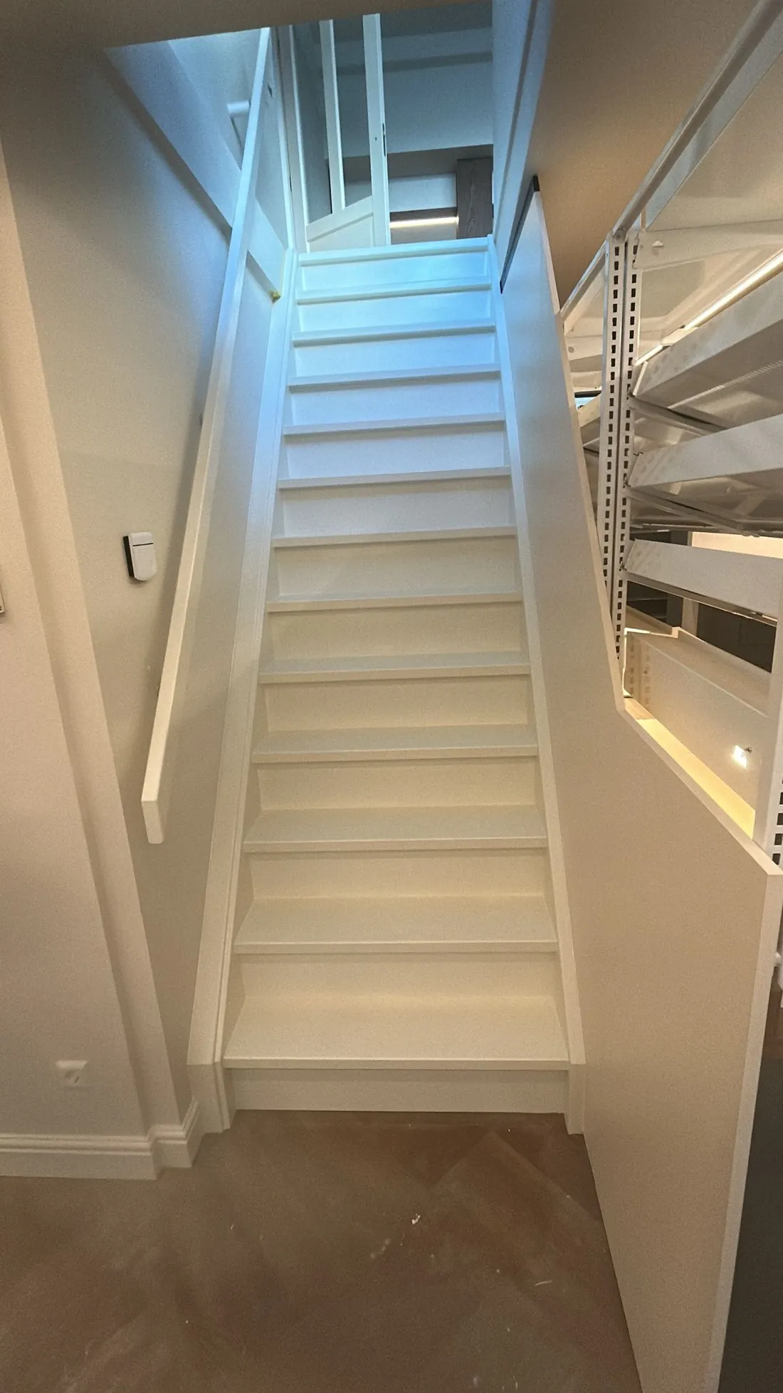 Wit geschilderde trap in een lichte hal